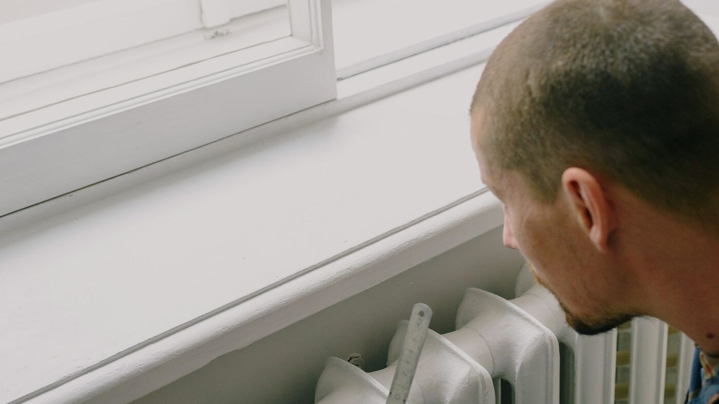 Real technician servicing a residential hot-water heating system.