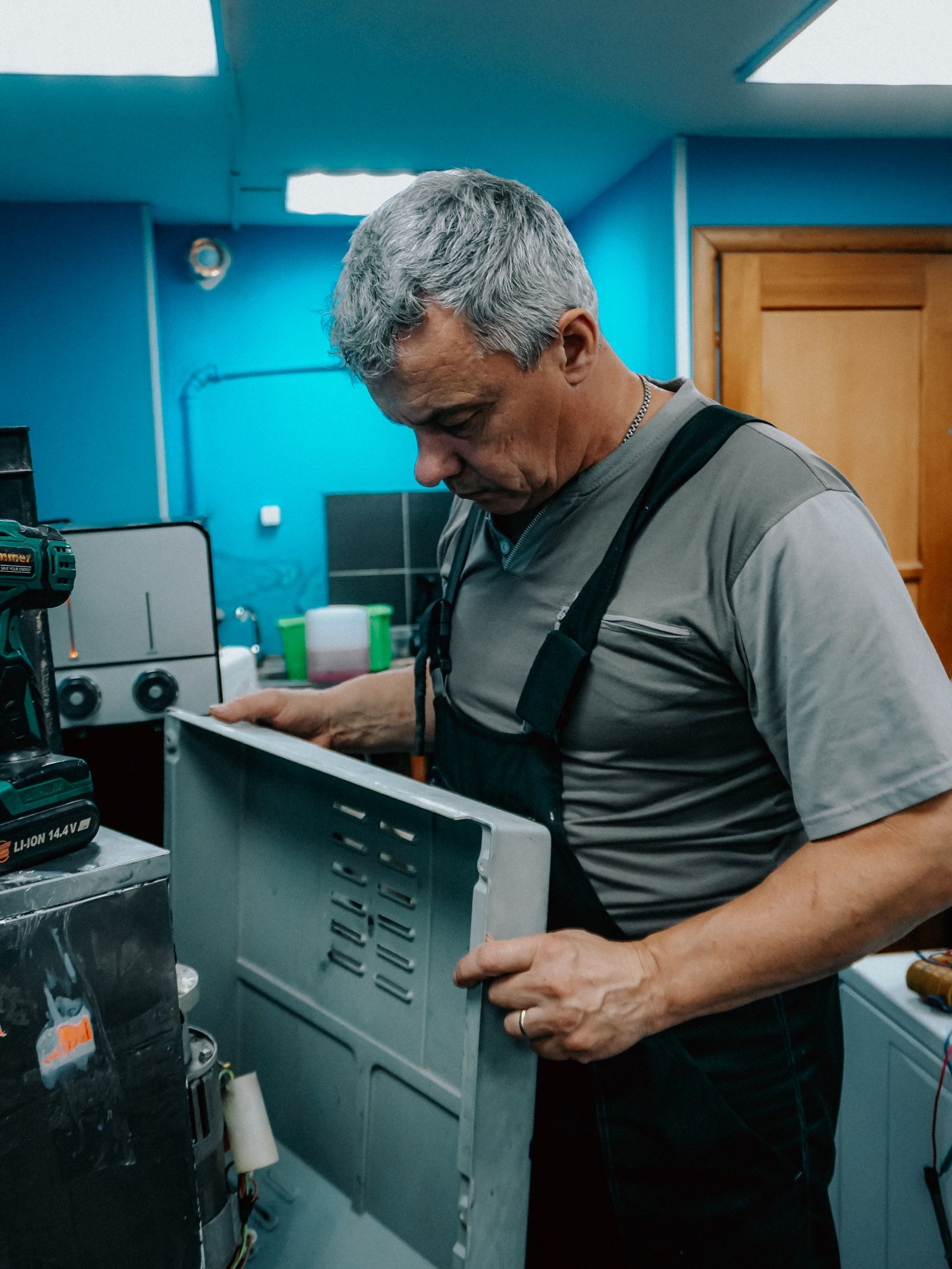 Real appliance repair technician inspecting equipment during a service visit.